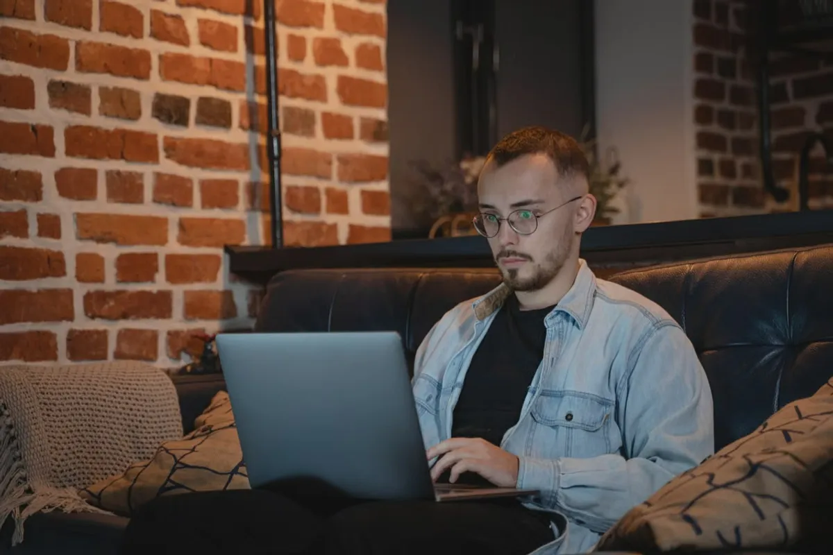Mann prüft am Laptop die Lizenzangaben eines Online-Anbieters