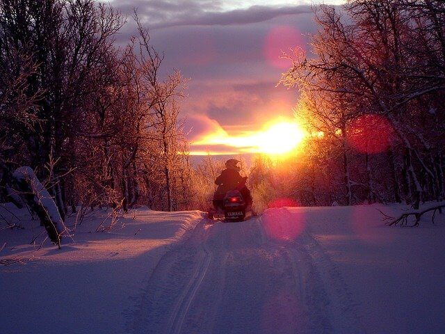 Schneemobilfahrt im Sonnenuntergang