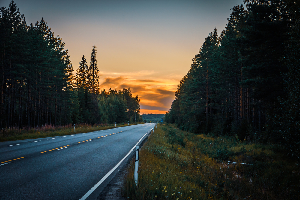 Leere Straße zum Sonnenuntergang in Finnland